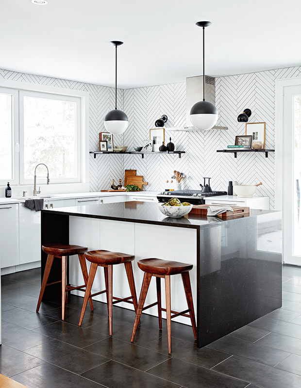Modern black-and-white kitchen with wood stools.