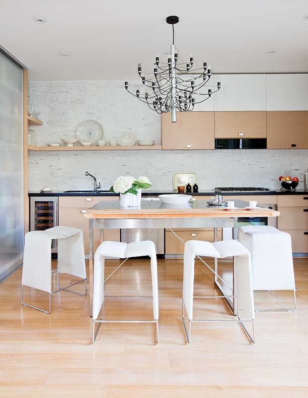 Blond modern kitchen with white stools.