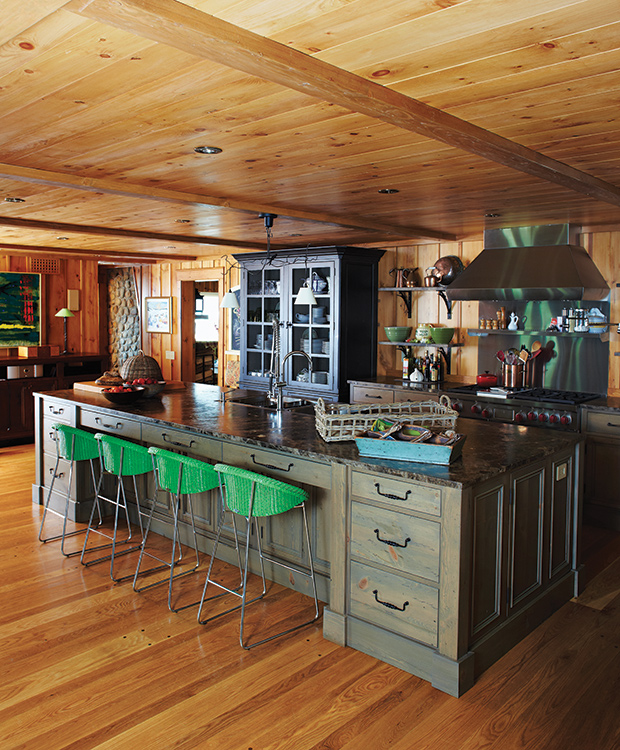 This cozy Canadiana lodge is the perfect fall getaway with its rich wood, dark cabinetry and exposed beams in the kitchen