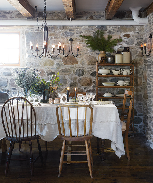 Rustic dining room with stone wall.