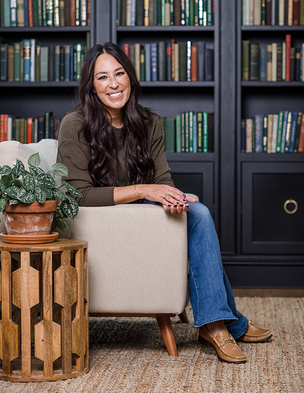 Joanna Gaines sitting on a chair in a library