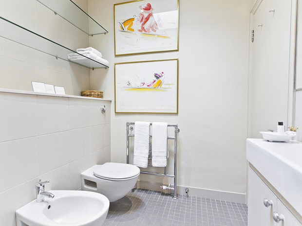 Madonna's London mews bathroom with colourful artwork and minimal white design.