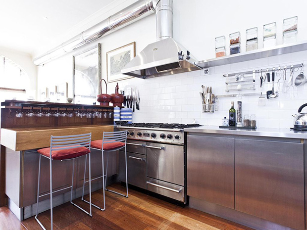 Madonna's London mews industrial kitchen with plush seating pillows.