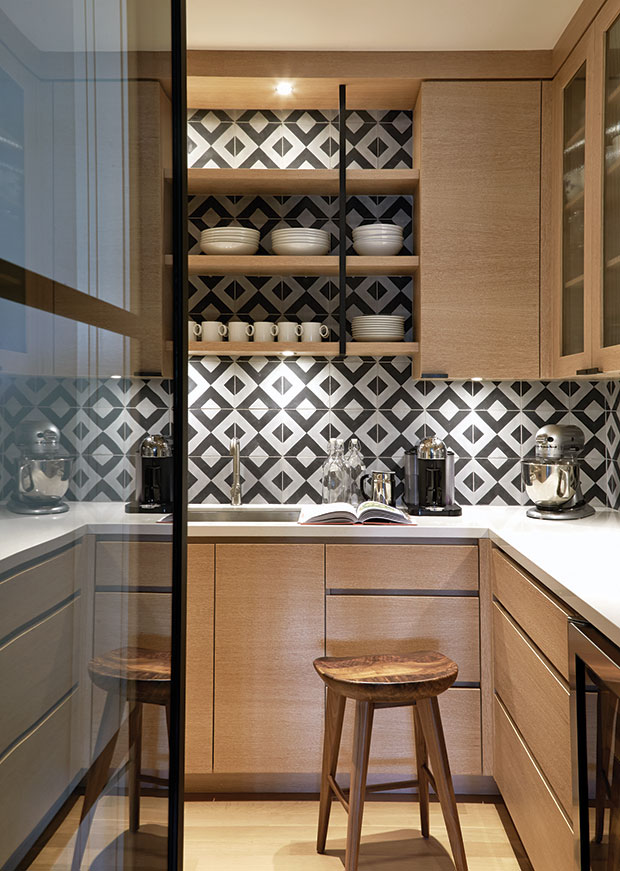 Nam Dang-Mitchell's design of a pantry with dramatic lighting and geometric cement tiles on the wall.