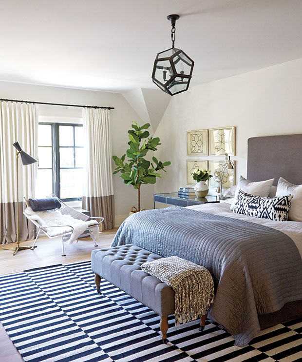 Nam Dang-Mitchell's design of a principal bedroom with a striped rug and geometric light fixture.
