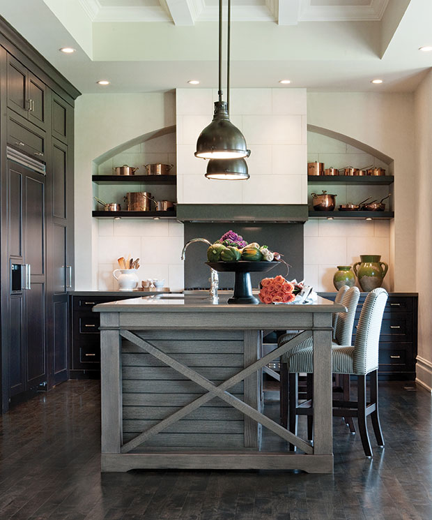 Nam Dang-Mitchell's design of a moody kitchen with a large island and industrial pedant lights.