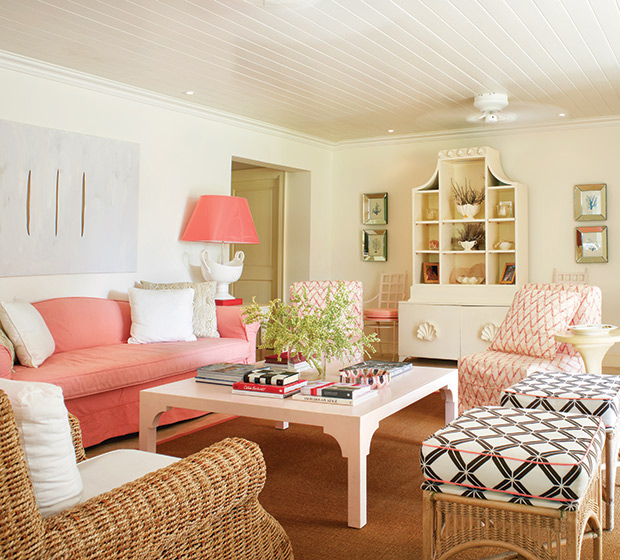 Whimsical living room with pink accents and coral sofa slipcover