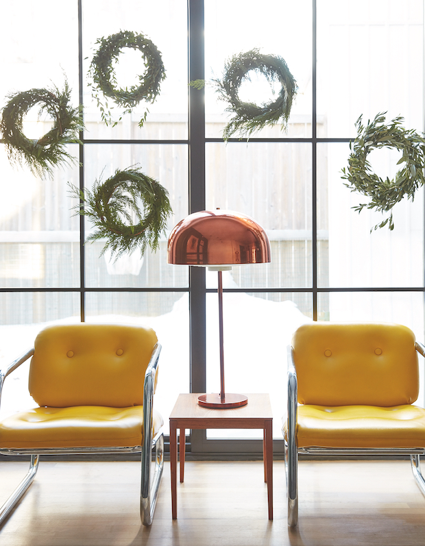 Living area with bright yellow chairs and hanging wreaths