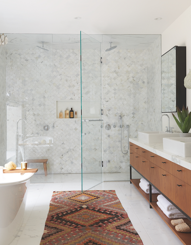 Marble bathroom with wood fixtures and rug