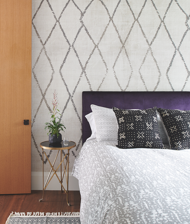 Wallpapered bedroom with rich purple headboard