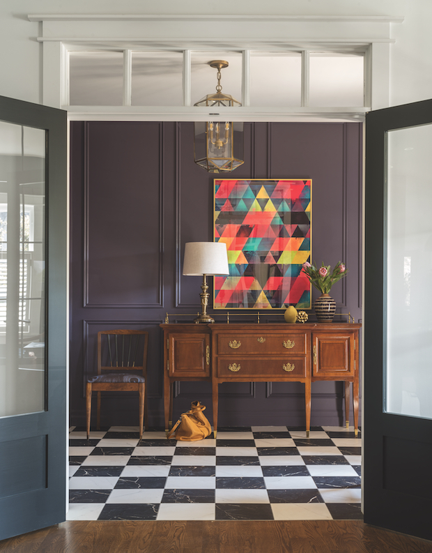 Moody entryway with plum panelled walls and wood table