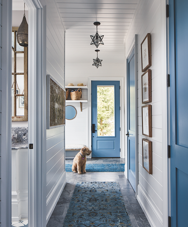 Light and airy entryway with blue doors and brass accents