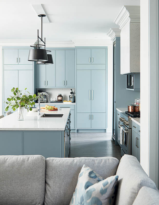 Pale blue kitchen cabinets brighten the room and complement the light grey of the family room.