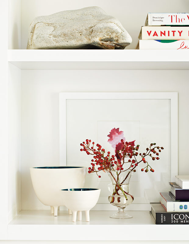 White shelving unit with a pop of red decor.