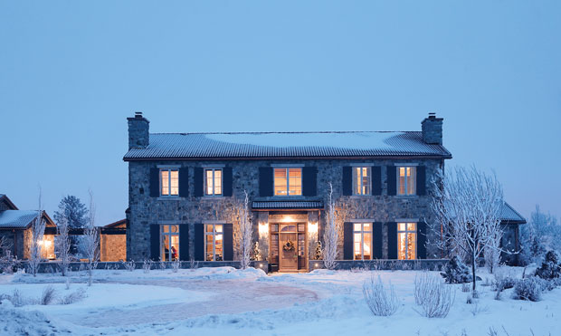 Holiday curb appeal — a sprawling home with lots of snow, glowing lights and cozy vibes