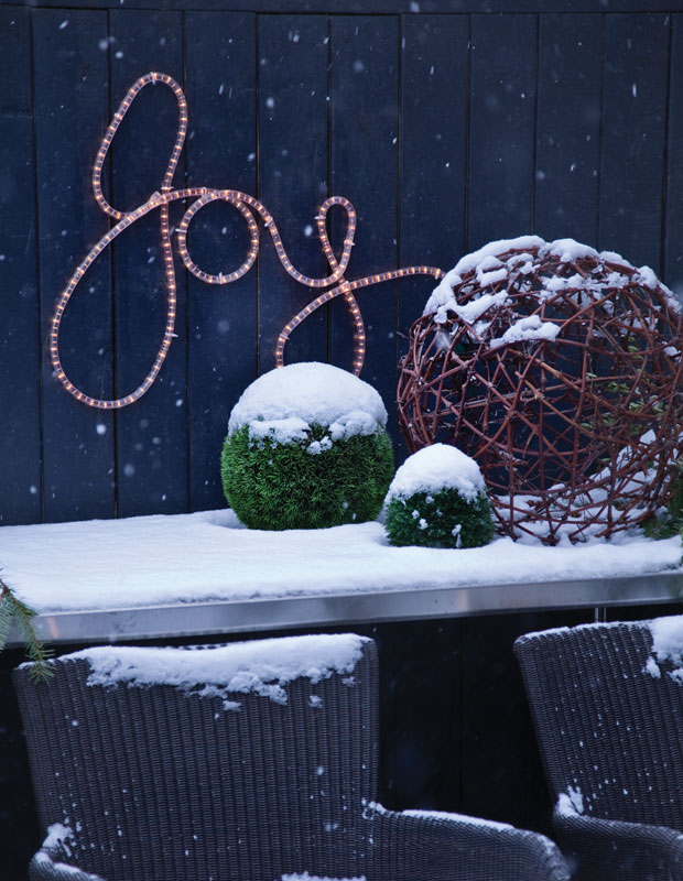 Holiday curb appeal — string lights saying "joy"