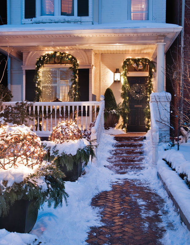 Holiday curb appeal — snowy front porch with lights and greenery