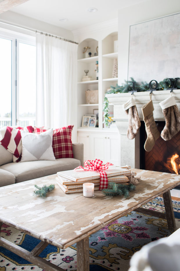 Jillian Harris celebrity Christmas decorations with red plaid pillows, stockings and a crackling fire