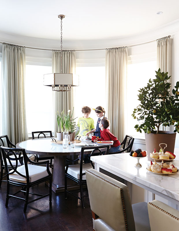 Breakfast nook with a round table, Christmas greenery and silk drapes