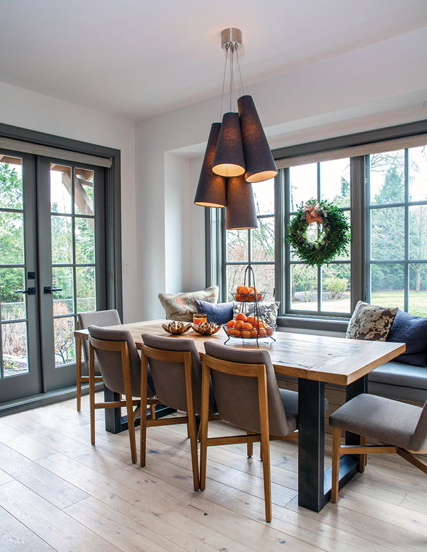 Breakfast nook with a long wooden table, wreath and window seat