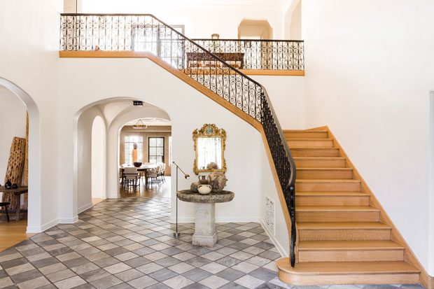 Nate Berkus and Jeremiah Brent entryway with a cascading staircase, tiled floor and curved archways