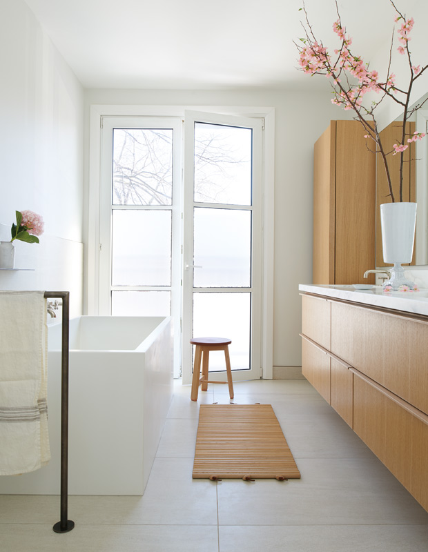 Minimalist spaces bathroom with wood cabinetry and a white tub