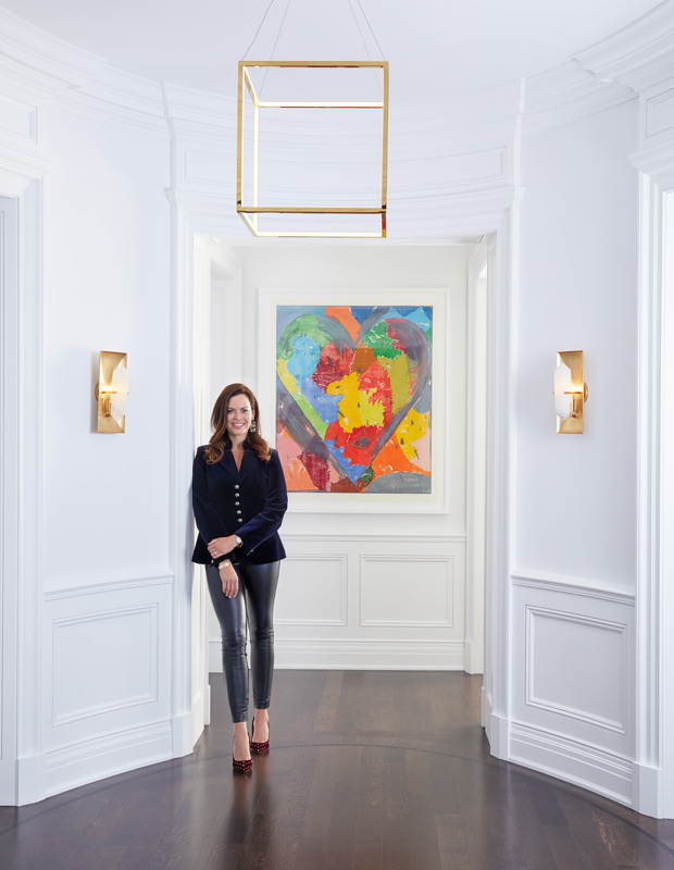 Anne Hepfer standing in the global family home's front entrance with a statement painting