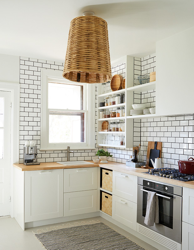 Organized family homes kitchen with statement subway tile and a breezy light