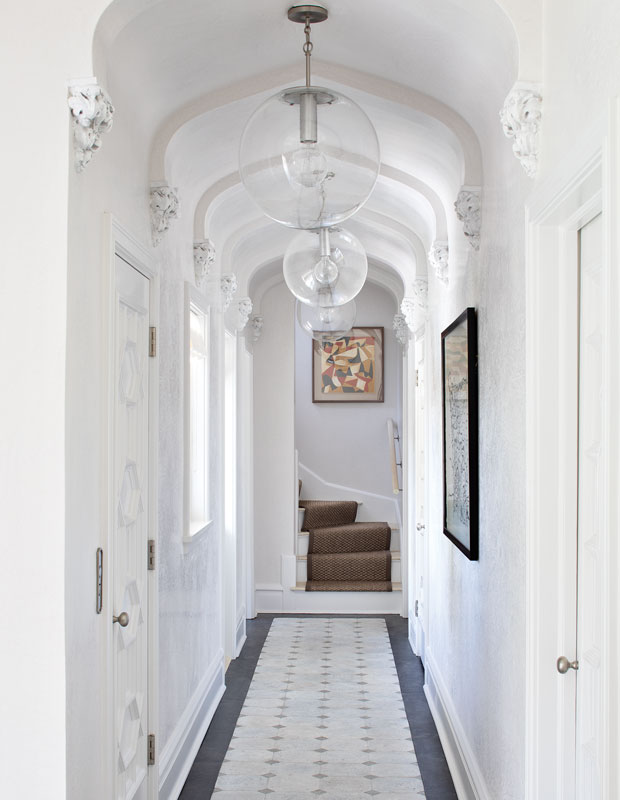 A white hallway in a Palm Beachhome with sphere pendant lights
