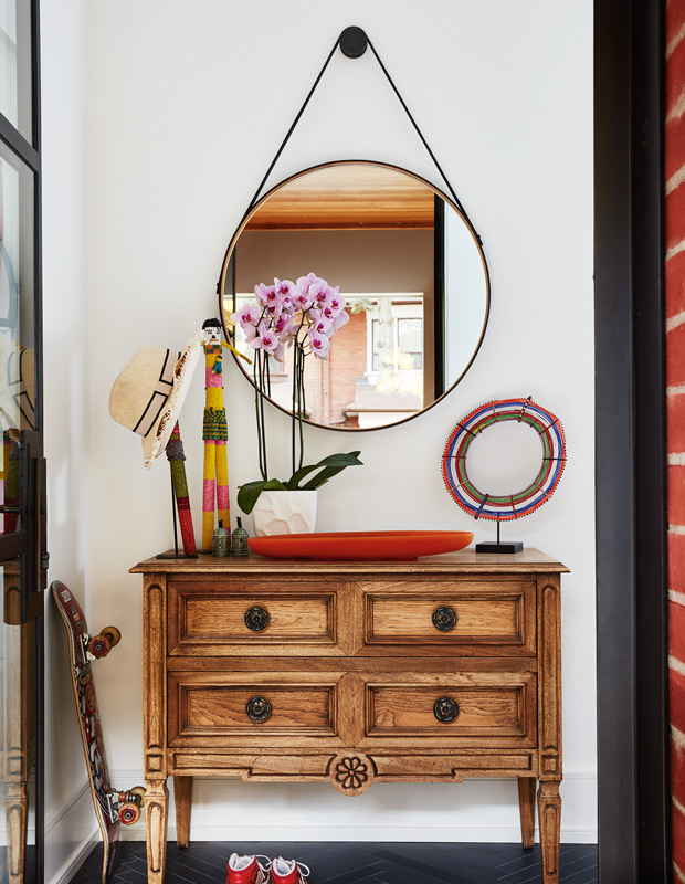 Ali Yaphe family home entryway with antique dresser and circle mirror