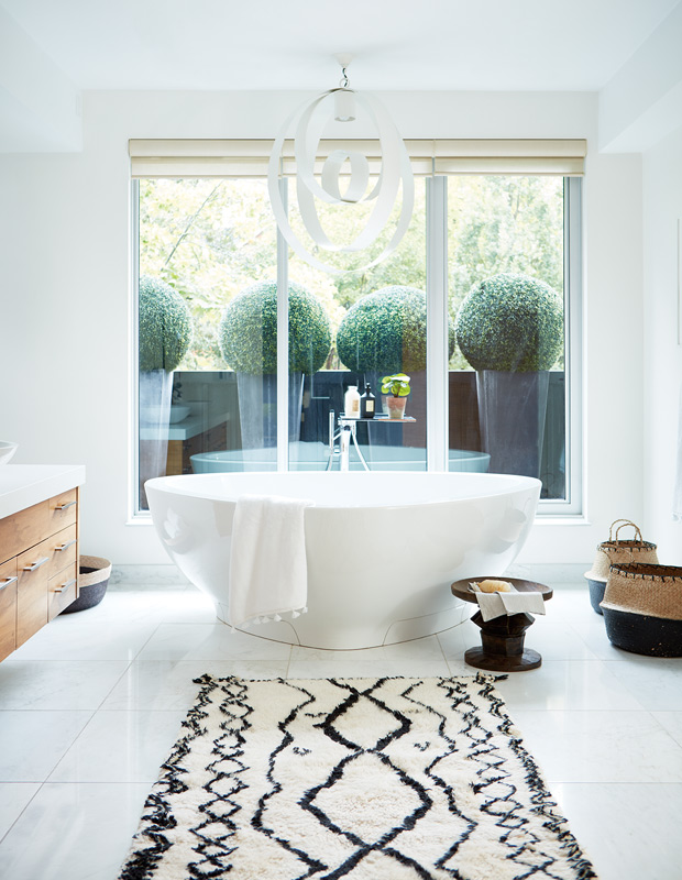 Global style master bathroom with Moroccan-inspired rug