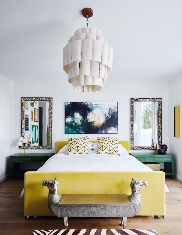 Global style bedroom with bright yellow bed and camel bench