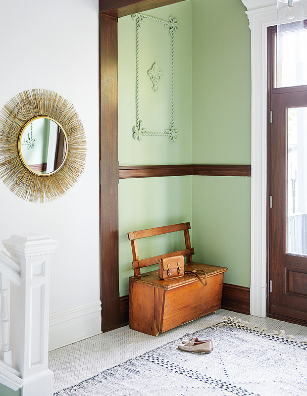 Colourful Montreal Home entryway with sunburst mirror and vintage wooden bench