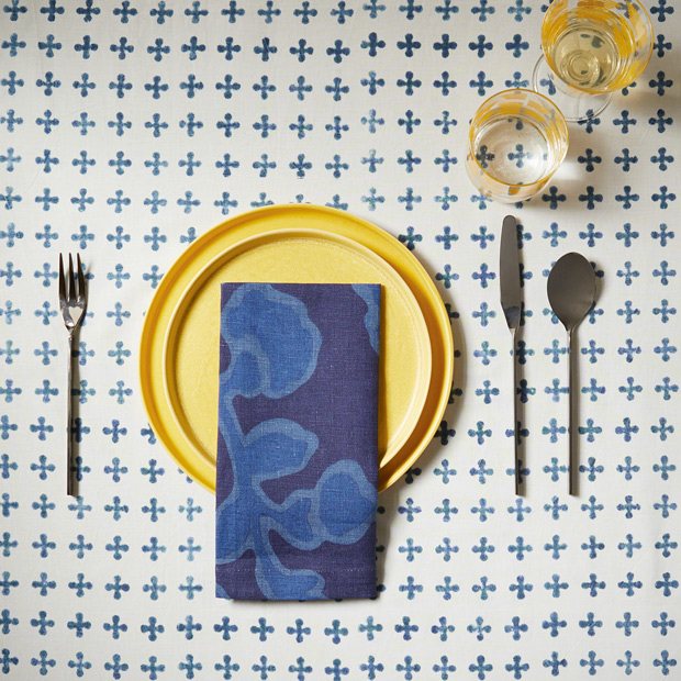 Summer table setting bright yellow plate with rich blue napkin