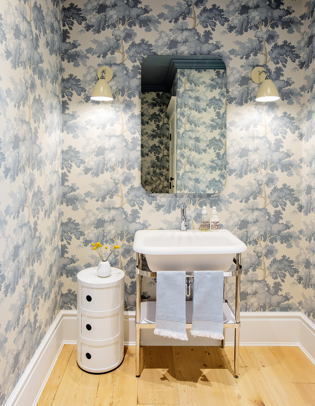 Powder room with soft blue forest wallpaper