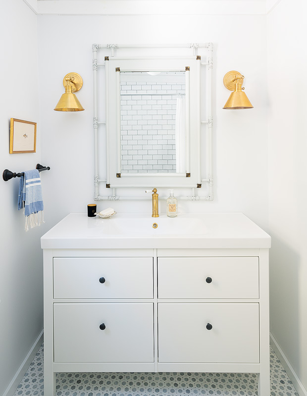 Lakeside cottage makeover compact principal bathroom with gold sconces