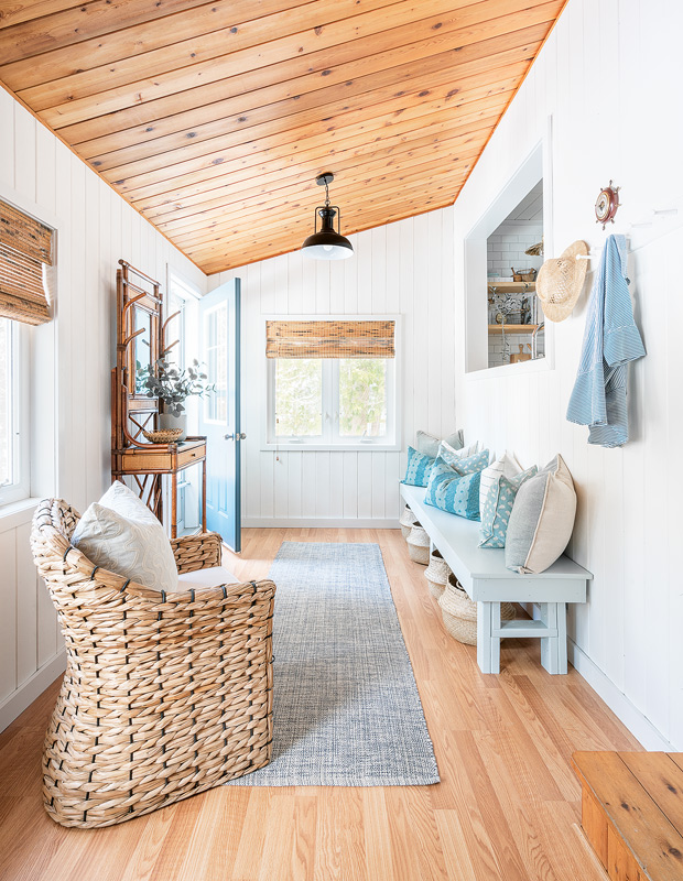 Lakeside cottage makeover front entrance with slanted wood ceilings and pops of blue
