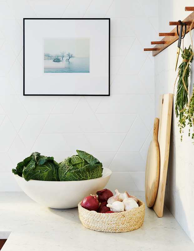 kitchen with natural wood cabinets and white tile set in a graphic pattern