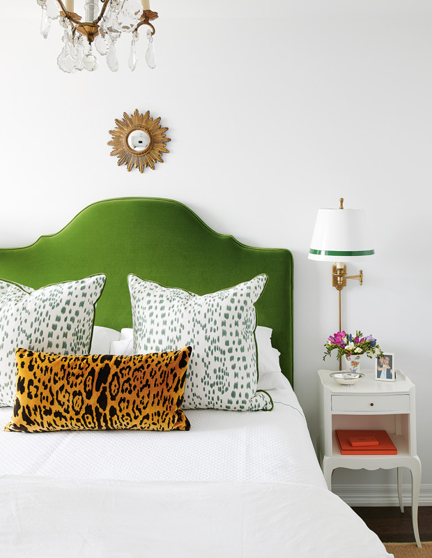 antique dealer's condo bold bedroom with kelly green headboard and cheetah pillow