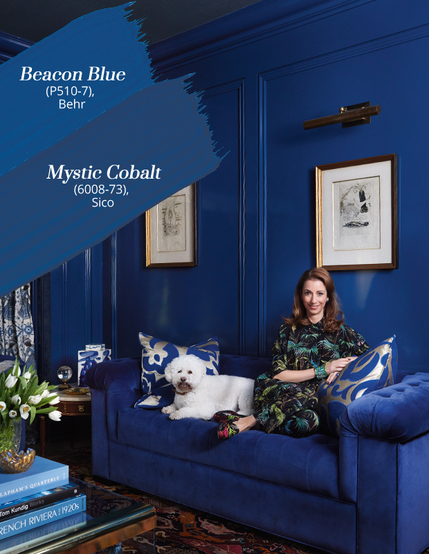 Amoryn Engel sits on a couch in a monochrome living room with gallery blue colors like "Beacon Blue" and "Mystic Cobalt".