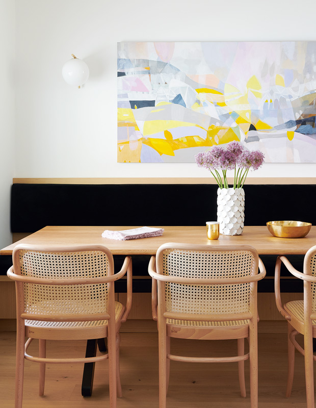 decorated minimalism banquette with perforated chairs and bright painting