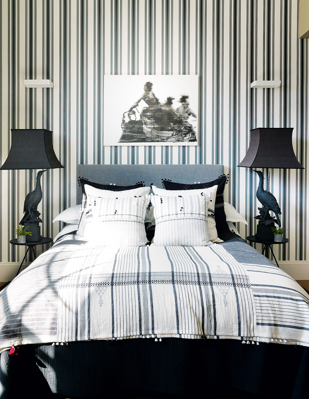 London flat principal bedroom with striped wallpaper and bedding