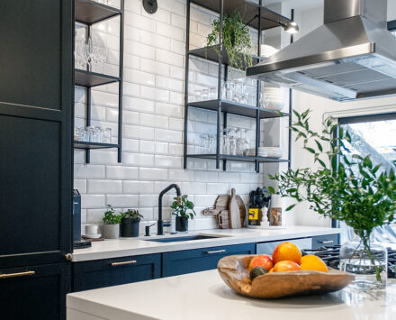 A black and white kitchen with potted plants from a Joel Bray Modern Home Makeover