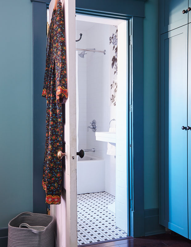 Ensuite bathroom doorway shown from inside the bedroom. Bedroom walls are turquoise and doors are blue.