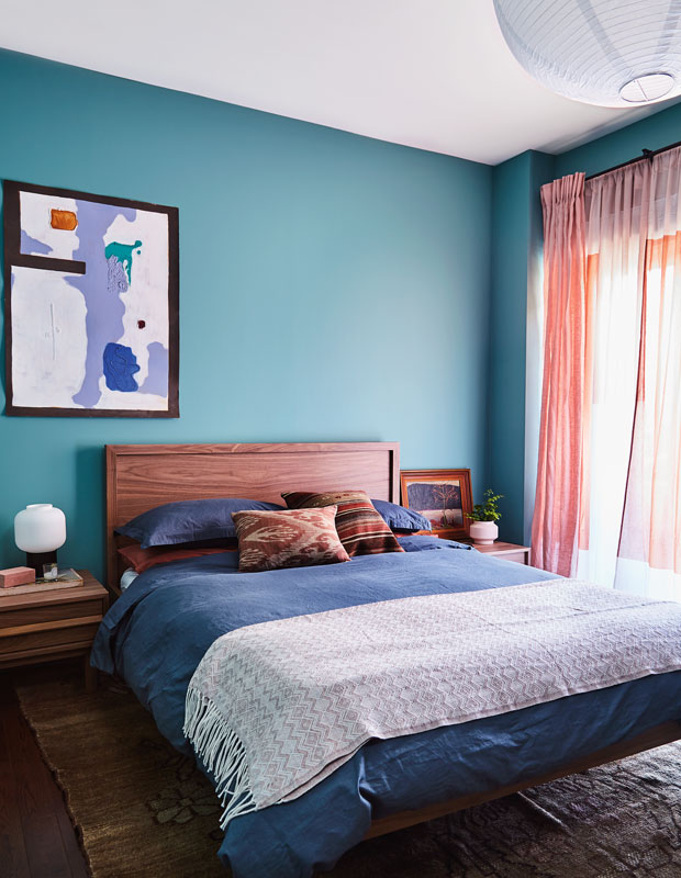 Bedroom with turquoise walls and abstract artwork