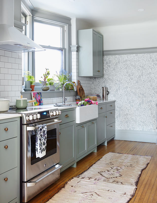 Kitchen with pastel greencabinets and white tile backsplash