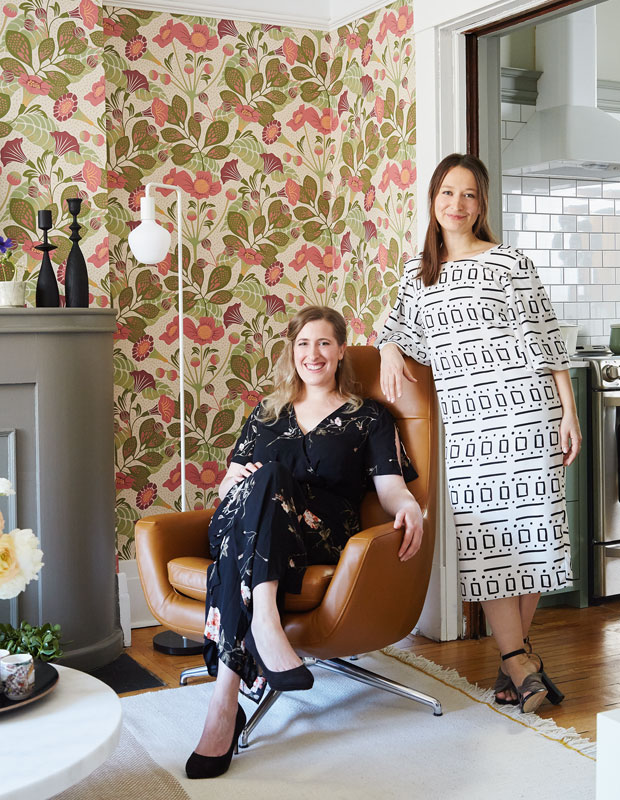 Designer Kai Ethier stands next to her sister Eden inside Eden's newly decorated living room.