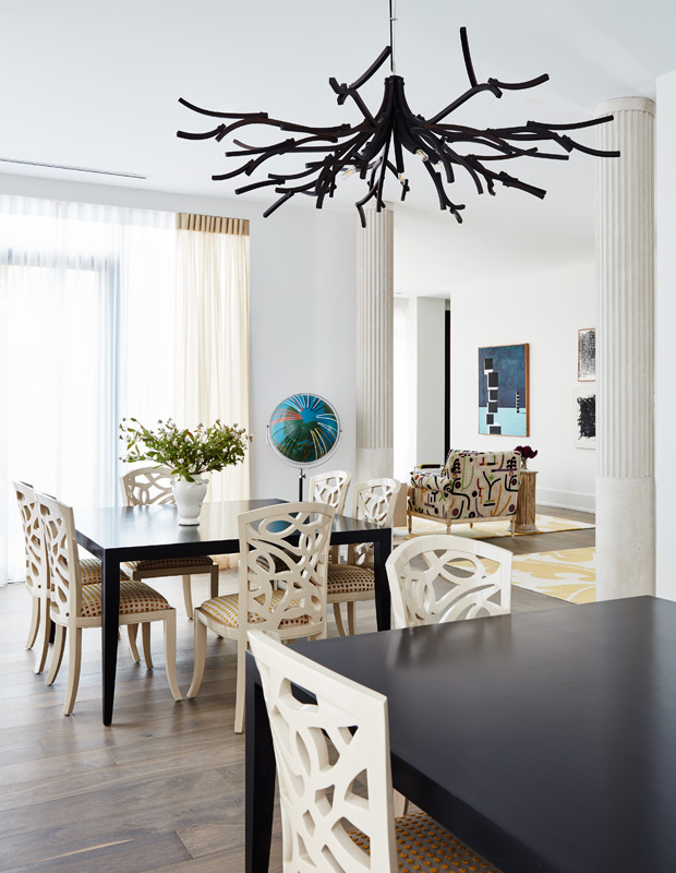 colorful condo dining room with cut-out chairs and tree-like chandelier