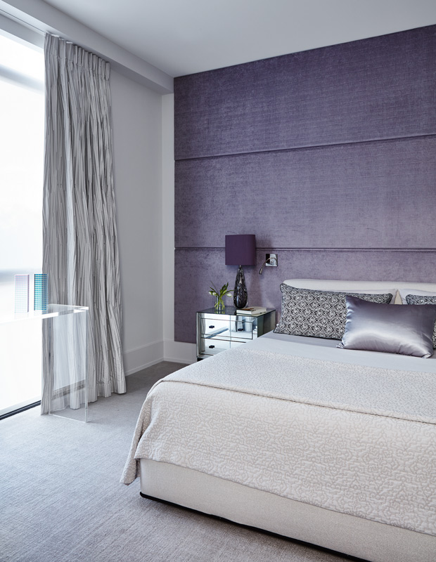 colorful condo principal bedroom with purple velvet walls