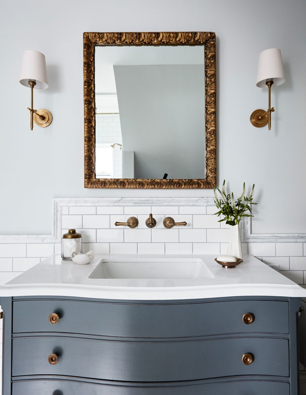Bathoom with a framed mirror above the sink and dusty blue cabinets